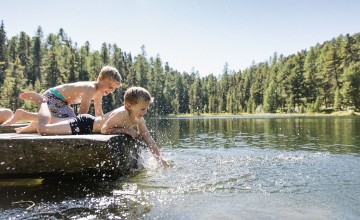 Zwei Kinder spielen am Wasser